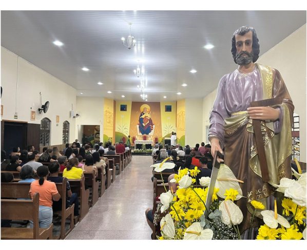 Imagem de uma celebração religiosa em uma igreja, onde destaca-se uma estátua de um santo ao primeiro plano, flores e um mural religioso ao fundo. 27.ª Festa em louvor a São José Operário acontecerá em Paranaguá