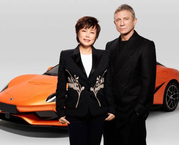 VP da BYD, Stela Li, ao lado do ator Daniel Craig e o Denza Z ao fundo, pintado de laranja