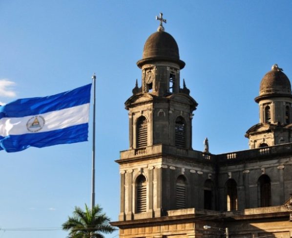 Bandeira da Nicarágua ao lado da Catedral Velha em Managuá, capital do país. (Foto: canva)
