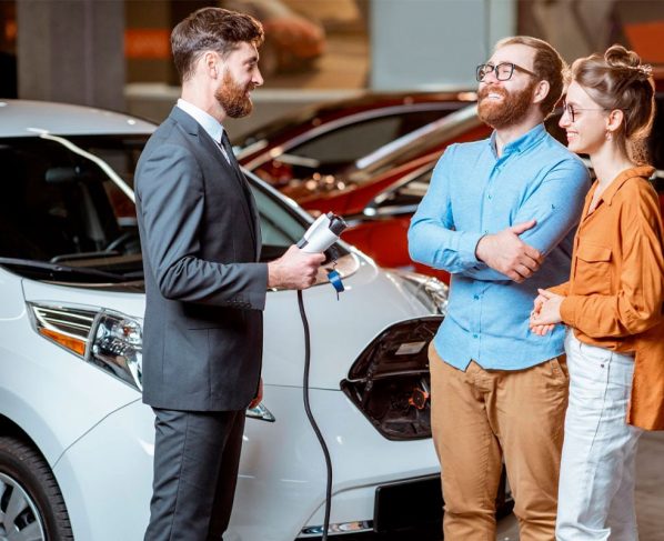vendedor mostra carro eletrico usado para casal