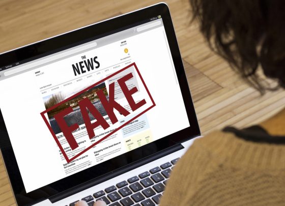 mulher olha fake news em computador